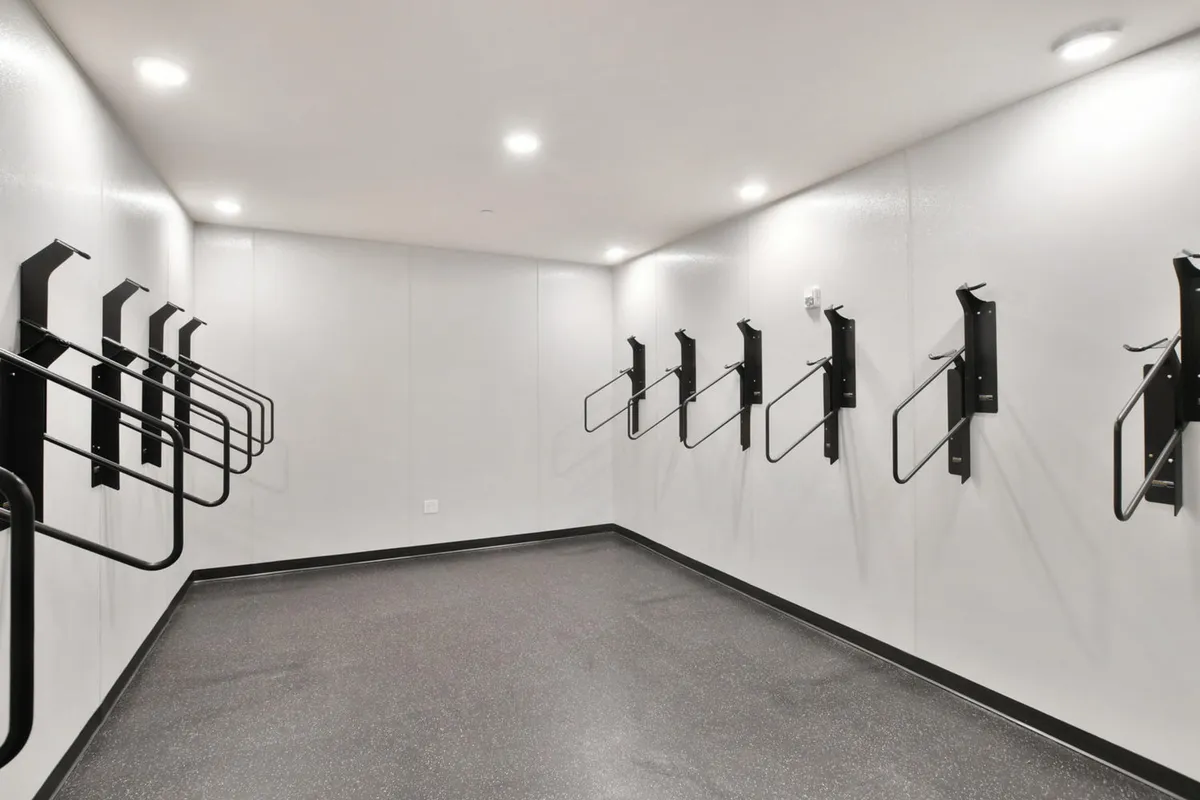 A clean, organized indoor bike storage area with bicycle racks and smooth flooring. The space is practical and secure, making it easy for residents to access and prepare their bicycles for nearby adventures.